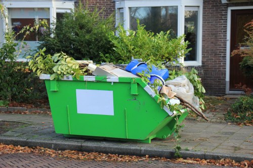 Team loading mixed waste into a skip on a suburban street
